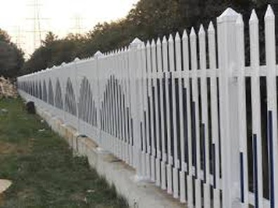 A PVC fence post being set into a concrete footing during installation A PVC fence post being set into a concrete footing during installation