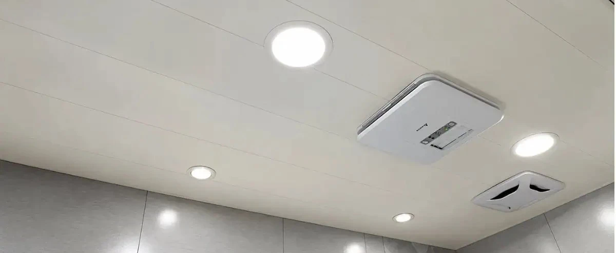 White glossy PVC ceiling board panels installed in a modern residential kitchen with recessed LED downlights showing seamless tongue and groove joint lines and uniform surface finish across the entire ceiling span White glossy PVC ceiling board panels installed in a modern residential kitchen with recessed LED downlights showing seamless tongue and groove joint lines and uniform surface finish across the entire ceiling span