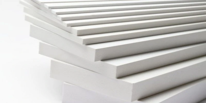 Stack of white PVC laminated 5mm foam board sheets with smooth glossy surface finish showing the three layer sandwich construction of solid PVC skin over expanded foam core ready for CNC cutting and printing applications Stack of white PVC laminated 5mm foam board sheets with smooth glossy surface finish showing the three layer sandwich construction of solid PVC skin over expanded foam core ready for CNC cutting and printing applications