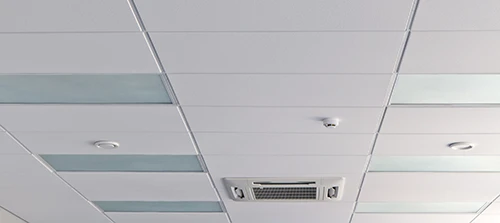 PVC ceiling board panels installed on battens in a basement ceiling showing clean seams and even alignment across the room PVC ceiling board panels installed on battens in a basement ceiling showing clean seams and even alignment across the room